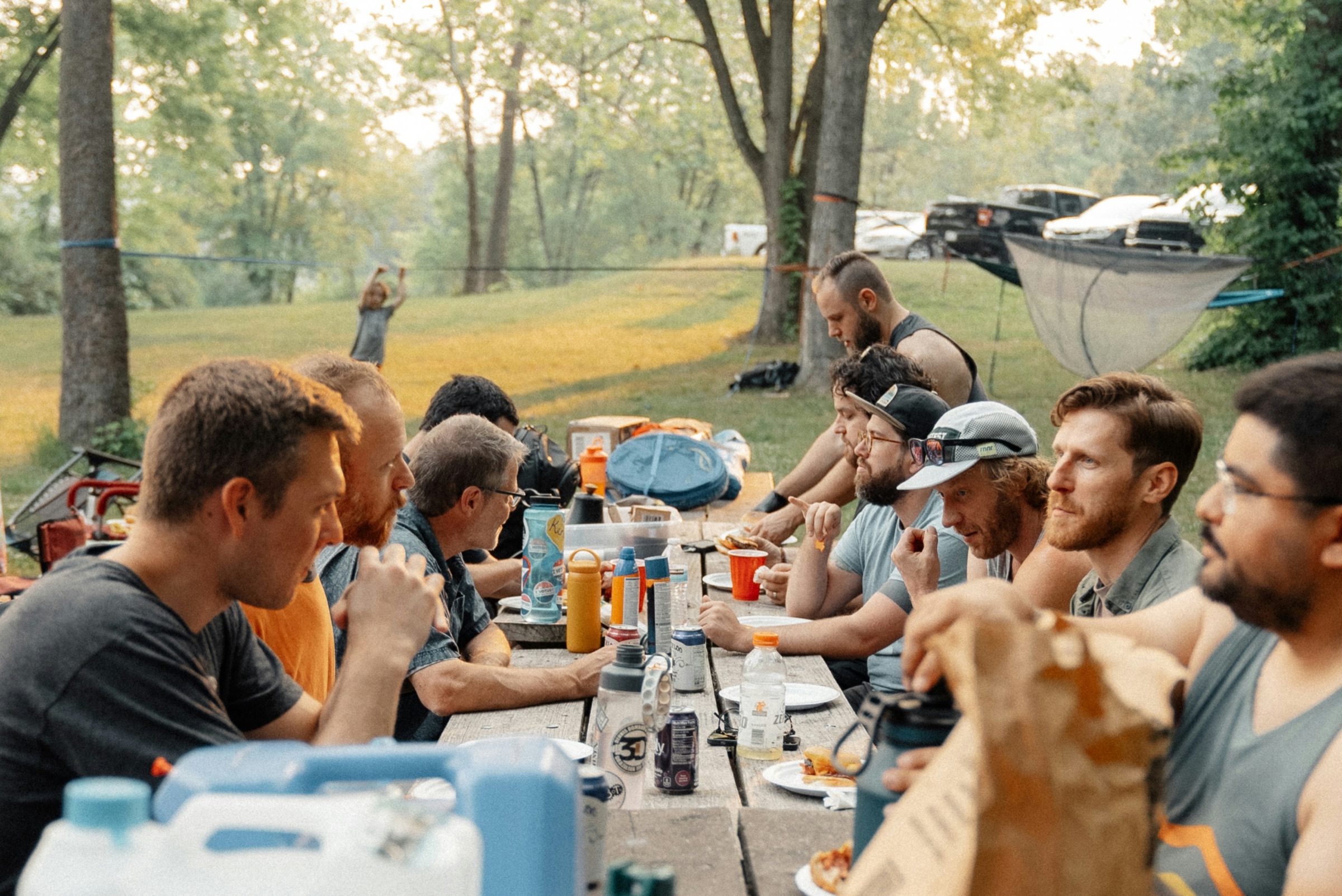 A host and volunteers sharing a meal together outdoors