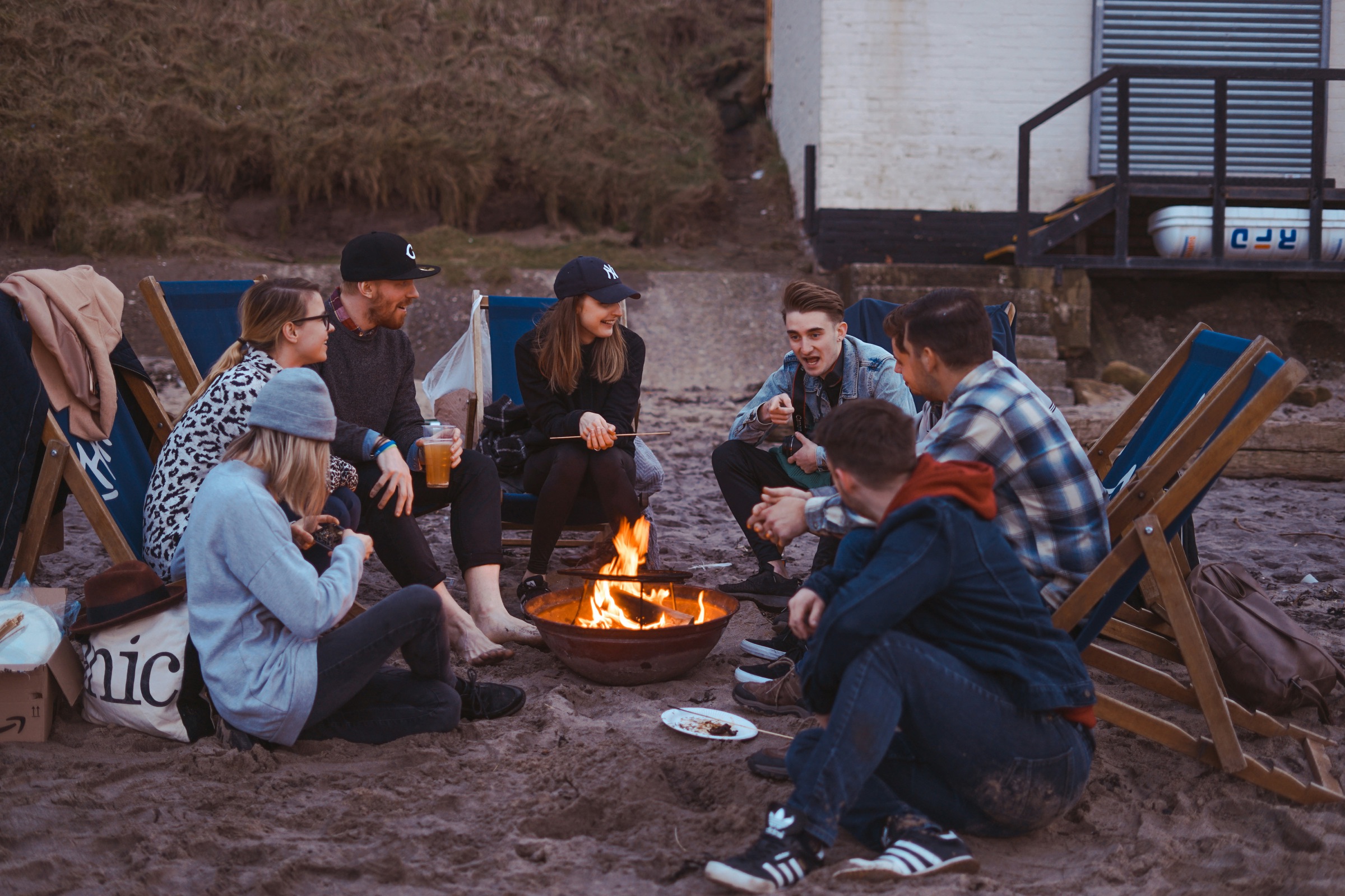 Volunteers sharing a bonfire together on the beach at dusk